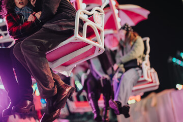 Joyful scene of individuals delighting in a nighttime carnival ride, capturing excitement and fun.