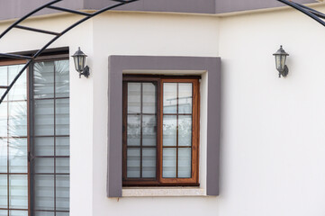 Fototapeta premium Charming wooden window framed by elegant architecture in a serene setting reflects peaceful outdoor ambiance