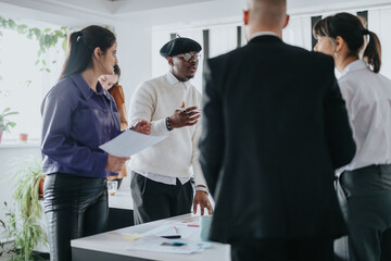 A group of professionals having a discussion during a team meeting in a modern office.