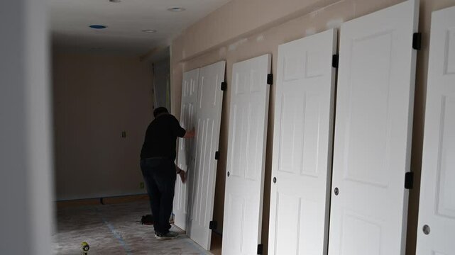 A man finally wipes the door before installing it.