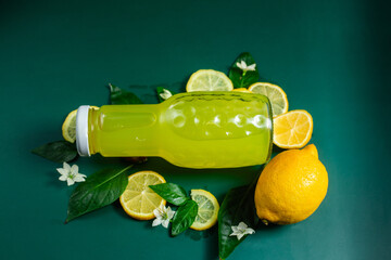 lemon juice and lemon slices on a green background
