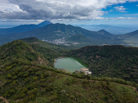 Aerial drone panorama of Laguna de Alegria - small lake with green water surrounded by lush green forest overgrown inactive volcano crater located in San Vicente province, El Salvador, Central America