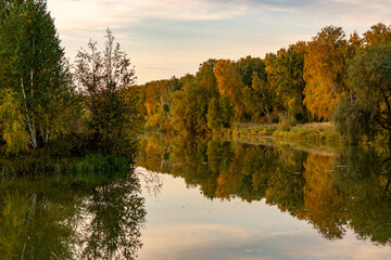 River landscape on a sunny autumn morning. The serenity and tranquility of an autumn morning on the banks of a narrow rural river.