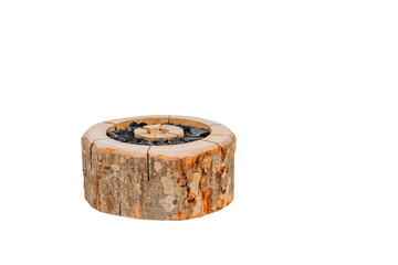 Low-cut round log fire starter filled with charcoal pieces, arranged in a spiral pattern. Rustic wood texture with bark detail on a white background. Copy space..