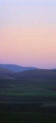 Obraz premium Serene landscape of rolling hills at dusk.