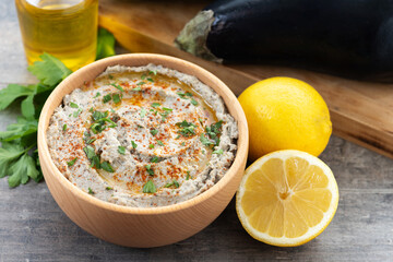 Traditional baba ganoush in bowl on wooden table