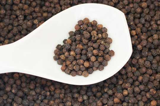 black pepper - kali mirch in white spoon background image