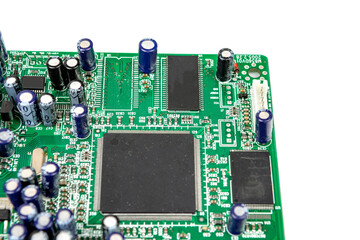 A close-up of the processor microchip surrounded by other electrical components on a green circuit board. Also on the board is a row of several speaker connectors.