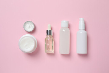 Natural cosmetic products on a pink background, top view