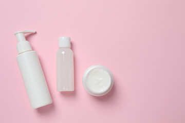 Natural cosmetic products on a pink background, top view