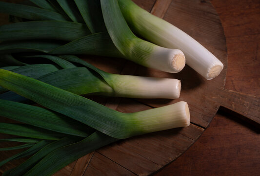 Fresh leeks with on wooden cutting board