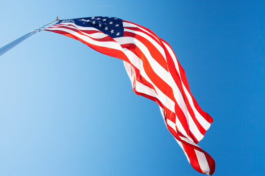 Ow angle view of American Flag against blue sky
