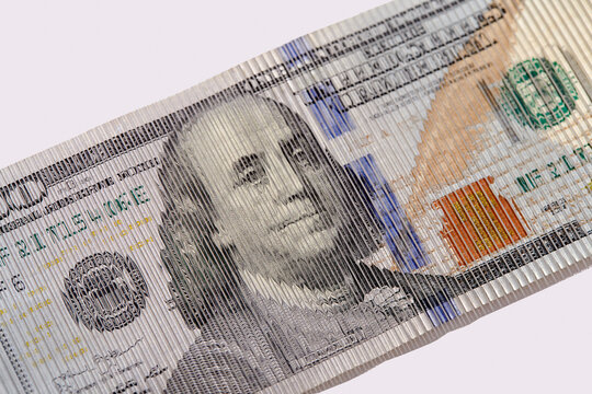 Studio shot of distorted one hundred dollar bill on white background