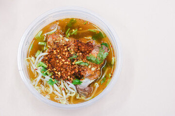 Pork tom yum noodles in a bowl on the table
