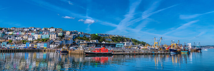 Brixham Devon panoramic view harbour fish market and houses on hillside with blue sea and sky UK