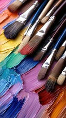Fototapeta premium Colorful paint strokes and artist brushes arranged artistically on a vibrant palette filled with a variety of hues