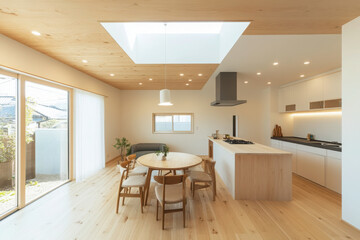 Fototapeta premium A bright and airy kitchen with a long countertop, small island, and round dining table bathed in natural light for a modern and inviting space