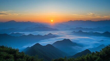 Obraz premium Serene sunrise over misty mountain ranges
