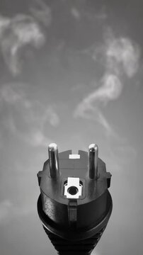 Close up of a European electrical plug emitting smoke