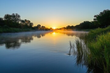 Obraz premium Golden sunrise paints misty river scene, light reflects on calm water surface