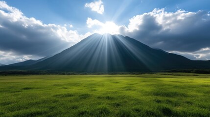 Majestic mountain peak, sun rays piercing clouds, vibrant green meadow