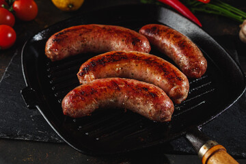 Pork sausages grilled on a pan. Image in dark tones