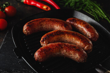 Pork sausages grilled on a pan. Image in dark tones