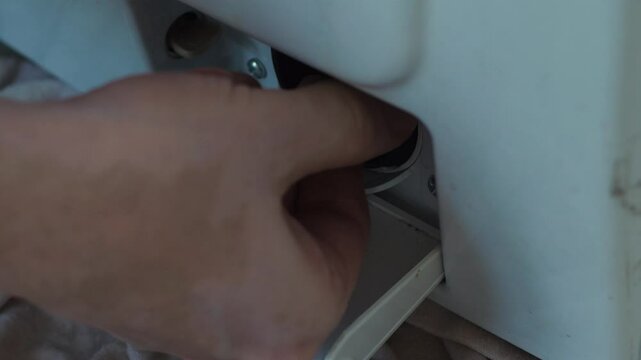 maintenance and repair of the washing machine concept, cleaning the washing machine, draining dirty water, cleaning the filter of the inlet hose