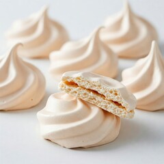 Close-up of meringue cookies, white and fluffy, with cracked pieces showing texture. Sweet treats, delicate and light dessert.

