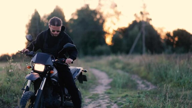 man on enduro motorcycle on country road in summer