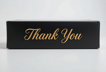 Stylish black box with elegant golden lettering saying Thank You, showcasing appreciation gifts for loyal customers during a corporate event held indoors, emphasizing gratitude and recognition
