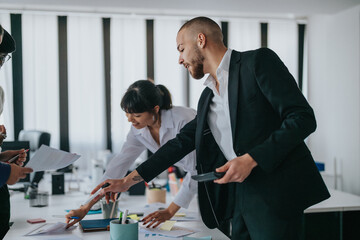 A team of professionals discussing documents and ideas during a collaborative business meeting in an office. The scene conveys teamwork, cooperation, and an energetic atmosphere during workplace