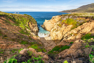 Stunning coastal landscape along California's Highway 1, featuring rugged rocky formations, and the vast blue ocean. A breathtaking natural scene showcasing the raw beauty of the Pacific coastline