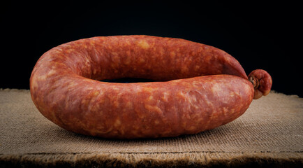 Krakow sausage on sackcloth. Circle of smoked sausage.