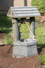 A tiny well with water coming from a bucket