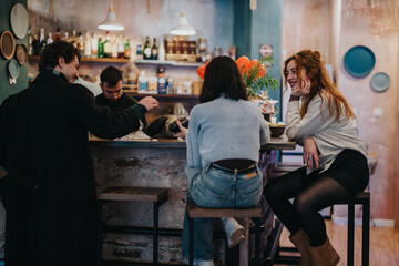 Fototapeta premium A cheerful group of friends enjoying quality time and conversations together at a lounge bar.