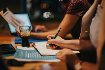 Diverse business professionals engage in a collaborative brainstorming and strategy session during a late-night meeting, highlighting creativity and teamwork. The scene conveys an atmosphere of focus