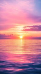 Obraz premium A breathtaking sunset casts vibrant hues across the ocean, with a stunning pink sky blending into soft orange and purple tones, reflecting beautifully on the calm water's surface.