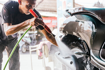 Motorcycle cleaning service with water spray and care
