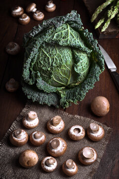 Fresh cabbage and mushrooms on rustic wooden table