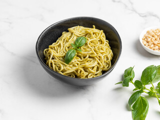 Italian pasta with pesto sauce and basil