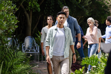 Guests walking through garden at outdoor small casual wedding, celebration, copy space, at home