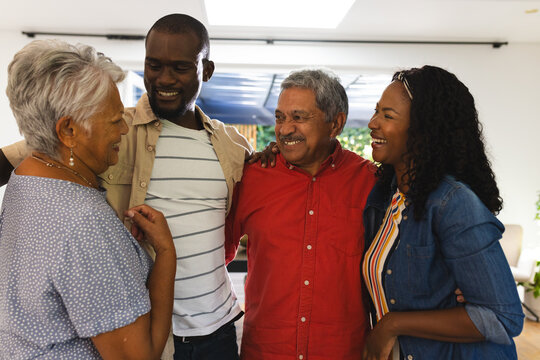 Diverse family embracing and smiling together at home, cherishing quality time