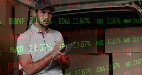 Image of financial data processing over delivery man writing on clipboard outside of warehouse