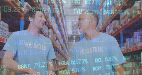 Stock market data processing over two caucasian male volunteers high fiving each other at warehouse
