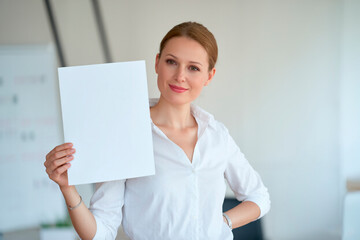 Naklejka premium creative businesswoman holding white A4 sheet of paper,