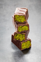 Dubai chocolate bar with crispy kataifi and pistachio paste. Dark background. Close up	