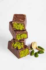Dubai chocolate bar with crispy kataifi and pistachio paste. White background. Close up	