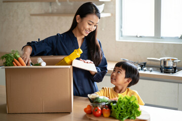 Mother and Son Unpacking Fresh Groceries in Kitchen