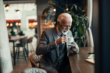 Senior Gentleman Enjoying Coffee in a Sophisticated Modern Cafe Setting